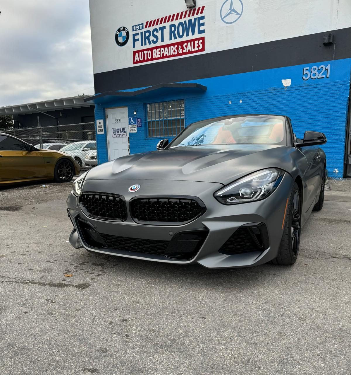 First Rowe's blue building at 5821 Rodman St with a BMW Z4 parked out front